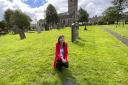 Kirkby Lonsdale Churchyard tour feature. Guide Tess Pyke at the unassuming grave of Brigadier General Wyatt in St Mary's Church yard