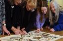 Volunteers study the first panel of the modern Bayeux-style tapestry being made in Norfolk (photo: Denise Bradley)