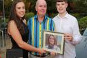 Chris Feeney with children Rosanna and Marcus holding a photograph of mum, Phillipa
