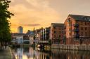 Redeveloped warehouses and modern bridge on the River Aire in Leeds at Sunset
