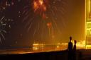Empire of Light actors Olivia Colman and Micheal Ward watch fireworks over the Margate Harbour Arm.
