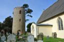 Bramfield church's round tower stands aloof in the graveyard