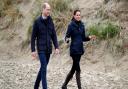 The Duchess of Cambridge is wearing a Troy London navy parka as she walks on a Welsh beach with Prince William