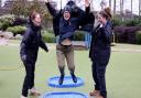 Grown up fun too, Sue Kinsey puddle jumping, cheered by colleagues Alice Litchfield and Becky Titchard, from the WWT Slimbridge education and engagement team, who organise the puddle jumping championships.