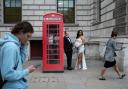 A newly married couple have their picture taken beside a red phone box at Parliament Square in Westminster