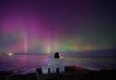 The aurora borealis, also known as the northern lights, appears over Bamburgh Lighthouse, in Northumberland on the North East coast of England