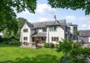 Front elevation with lawned garden, terrace and detached triple garage