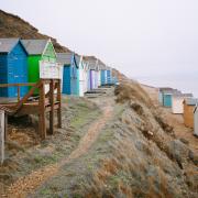Candy coloured beach huts on Milford on Sea Beach, one of Hampshire's Dog-Friendly Beaches