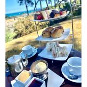 Afternoon tea on the terrace at Knoll House Hotel, with Studland Bay beyond