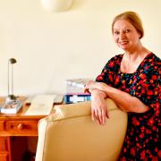 Booker Prize-winning author Dame Hilary Mantel with the desk she is selling in aid of Budleigh Literary Festival.