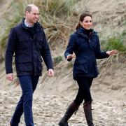 The Duchess of Cambridge is wearing a Troy London navy parka as she walks on a Welsh beach with Prince William