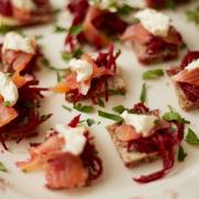 Rye bread squares topped with beetroot hash, horseradish cream and smoked salmon