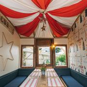 The carriages and double decker bus where tables are placed are decorated in quirky designs