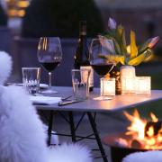 Enjoy a glass of wine by the fire with friends while dining outdoors at Heckfield Place