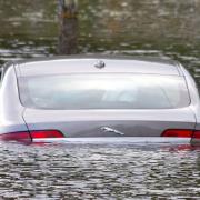 A motorist's car becomes submerged after trying to cross at high tide. Photo: John Ashton