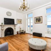 The first floor reception room with period fireplace and access to a seaview balcony