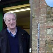 Sir Michael Caine beside the Blue Plaque  commemorating  his first  acting role at North Runcton School.