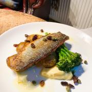 Fried sea bass fillet on a plate with vegetables