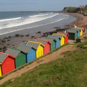 Whitby beach with its bright beach huts. (c) Paul Kirkwood