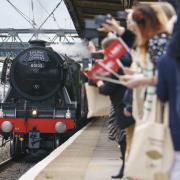 Guests look on as Flying Scotsman arrives at Doncaster Railway Station, celebrating her centenary by making a return to the city where she was built one hundred years ago