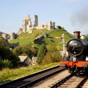 A Swanage Railway steam train chuffs by the ruins of Corfe Castle. Photo: Martyn Evans/Alamy Stock Photo