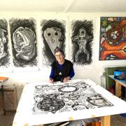 Christine in her studio at Lyme Regis with some of her Treasure drawings behind her. (PHoto: