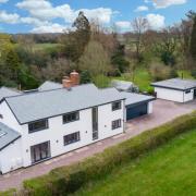 Aerial view of house, driveway, detached outbuilding and surrounding fields