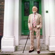 Sir John Mills stands on the doorstep of the former Norwich High School for Boys, in Upper St. Giles Street.