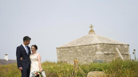 Bride and groom with their memorable Dorset wedding location, the 12th century St Adlhelm's chapel. (Photo: Tim Churchill Photography/sunflowerco.co.uk)