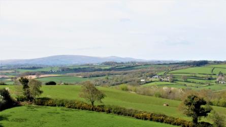 Views across undulating farmland towards distant Dartmoor